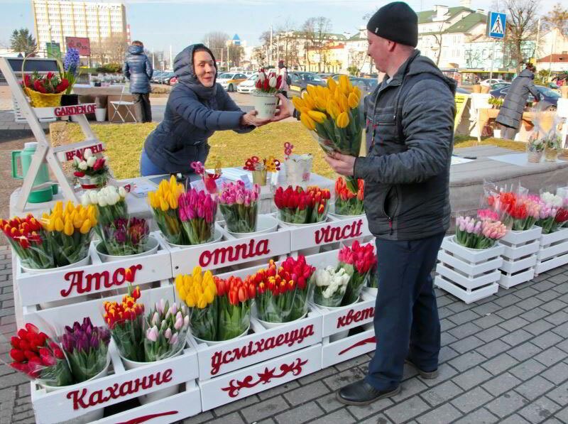 Женщина продает тюльпаны в розинцу на 8 марта 