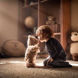 Огромный плюшевый медведь сидящий на кровати